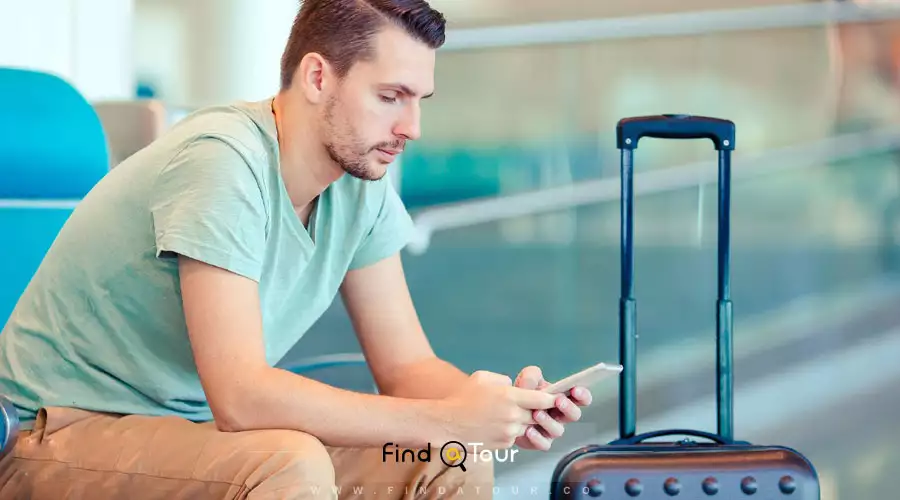 گردشگر مرد اروپایی با چمدان در فرودگاه بین المللی 