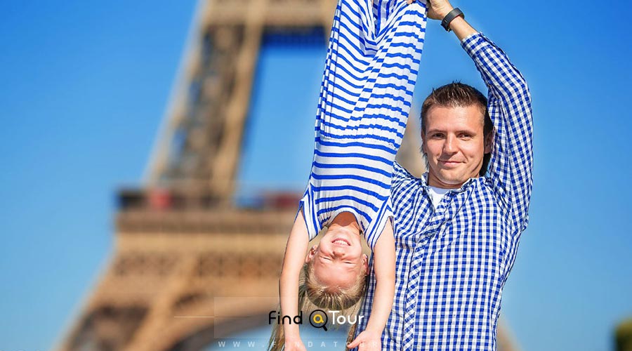 پسر و پدر اروپایی در حال بازی در محوطه برج ایفل فرانسه 