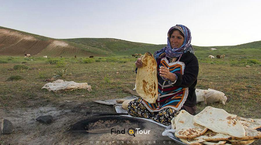 عکس یک خانم روستایی درحال پختن نان محلی ایران